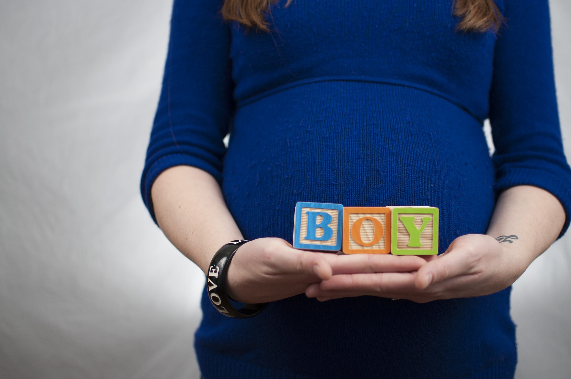 Image of Pregnant Woman Holding Wooden Blocks that Spell Boy